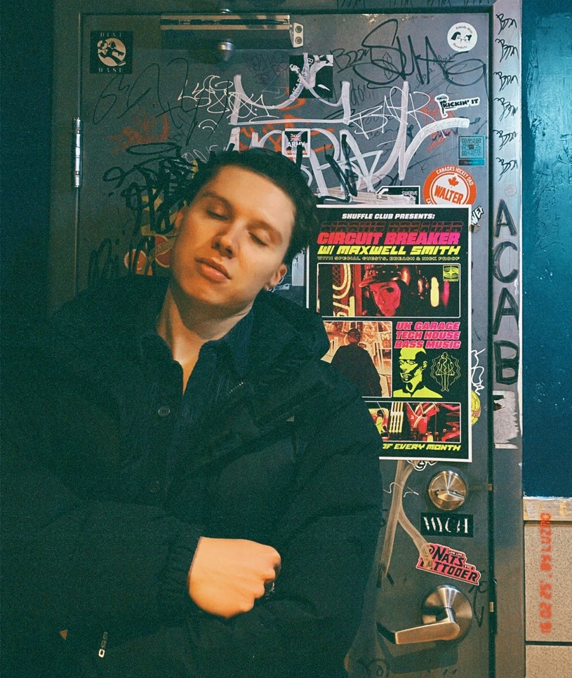 mxxwxll smxth standing in front of a signed venue door